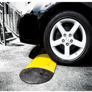 rubber black and yellow speed bump with car on top of it