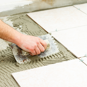 tiling white tiles using adhesive and trowel