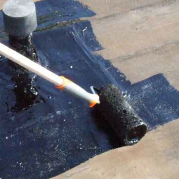 applying black water based bitumen primer using a roller
