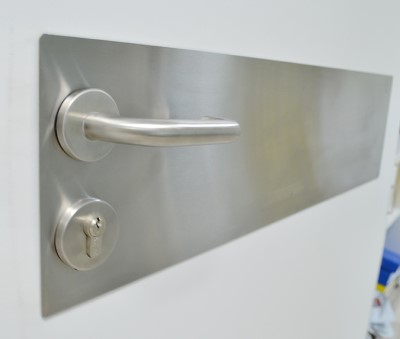 silver door kick protection plate near door knob
